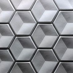 a close up view of a metal surface with hexagonal tiles in silver and white