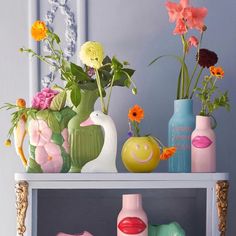 vases with flowers and other decorative items on a shelf