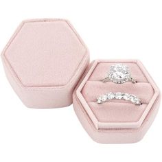 two engagement rings are in a pink velvet ring box with hexagonal opening on the inside