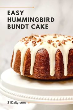 a bundt cake with white icing and pecans on top, sitting on a plate