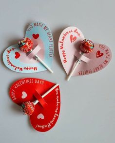 three valentine's day candy lollipops are on top of each other