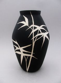 a black vase with white designs on it