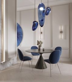 an elegant dining room with blue chairs and art glass chandelier hanging from the ceiling