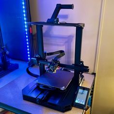 a 3d printer sitting on top of a table next to a phone and other items