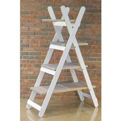 a white wooden step ladder leaning against a brick wall