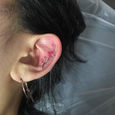 a woman's ear with pink flowers on it