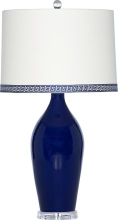 a blue table lamp with a white shade on the base and a light in front of it