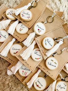 some tassels are laying on the floor with name tags and key chains attached to them