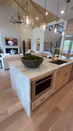 a large kitchen island with a bowl on the top and lights hanging from the ceiling