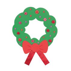 a green wreath with red bows and buttons on it, sitting against a white background