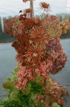 an arrangement of flowers in a vase on a table