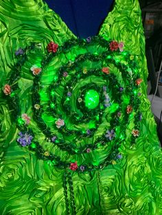 a green dress with flowers and beads on it