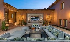 a living room filled with lots of furniture next to a patio covered in potted plants