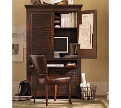 a computer desk with a chair in front of it and bookshelves on the wall