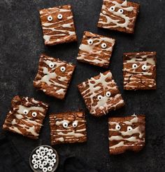 brownies with eyes and googly eyes are arranged on top of a black surface