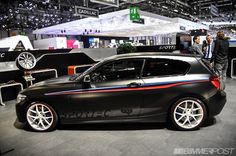 a black car is on display at an auto show