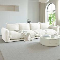 a large white couch sitting in a living room on top of a carpeted floor