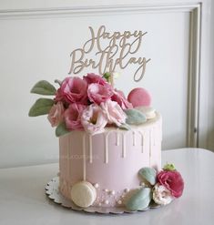 a pink birthday cake with flowers on top