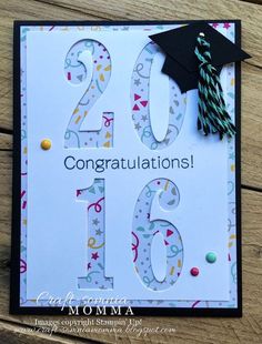 congratulations card with graduation cap and tassels on the top, in front of a wooden background