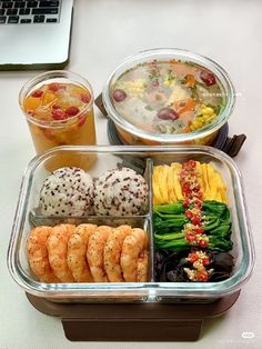 there are many different types of food in the trays on this table, including shrimp and rice