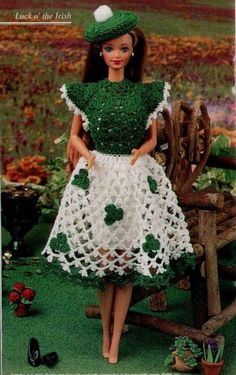 a crocheted doll in a dress and hat