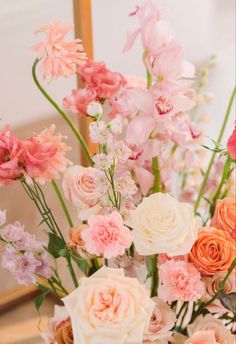 a vase filled with lots of pink and white flowers