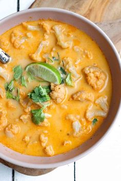 a bowl of soup with cauliflower and lime