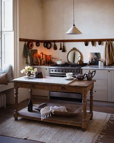 a kitchen with a table, oven and sink in it's center island area