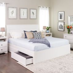 a bedroom with white furniture and pictures on the wall