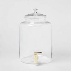 a glass jar with a gold ring on the lid and a clear plastic container underneath it