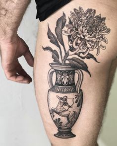 a man's thigh with flowers in a vase tattoo on it