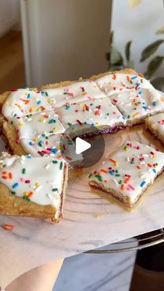 a person holding a plate with cake on it and sprinkles around the edges