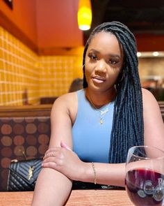 a woman sitting at a table with a glass of wine