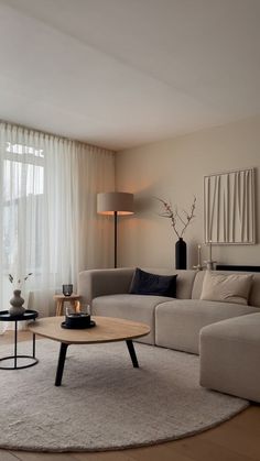 a living room with a couch, coffee table and large window in the back ground