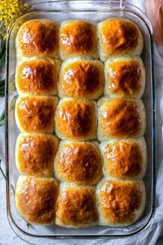 a baking dish filled with rolls covered in cheese