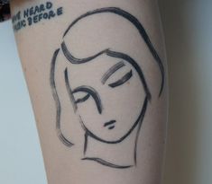 a woman's face is drawn on the side of her leg with black ink