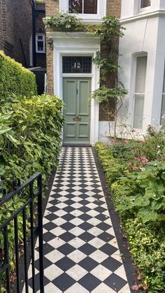 a black and white checkered walkway leading to a door