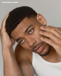 a close up of a person holding his hand to his head and looking at the camera