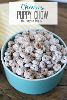 a blue bowl filled with cheerios puppy chow on top of a wooden table next to a