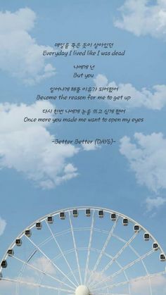 a ferris wheel with the words written in korean on it and an image of a ferris wheel under a cloudy blue sky