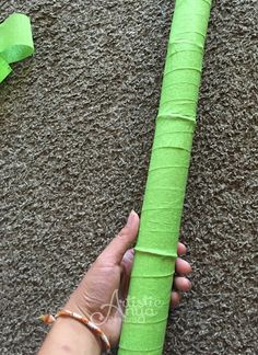 a person is holding a green paper roll