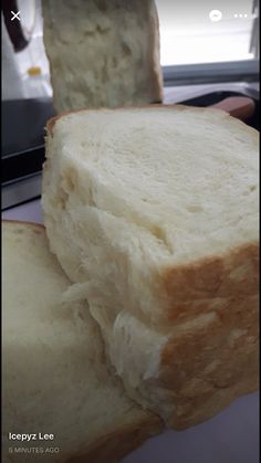 two pieces of white bread sitting on top of a table next to each other,