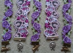 three pieces of purple and green lace with flowers on them are laying next to each other