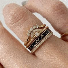 a close up of a person's hand with two rings on their fingers and one ring in the middle