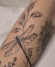 a black and white photo of a dragonfly on the arm