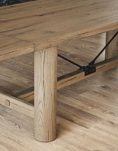 a wooden table with metal straps on the top and bottom edge, in a living room