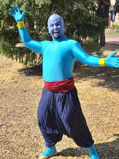 a man dressed in blue and yellow poses for the camera with his arms outstretched out