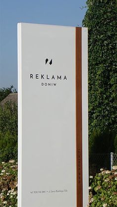 a large white sign sitting in the middle of a garden