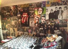 a bedroom with a bed and wall covered in posters