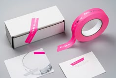 a box with some pink tape on top of it next to other boxes and papers